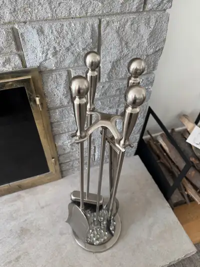 Brushed nickel finish fireplace tool set. Includes shovel, poker, log gripper, broom and stand.