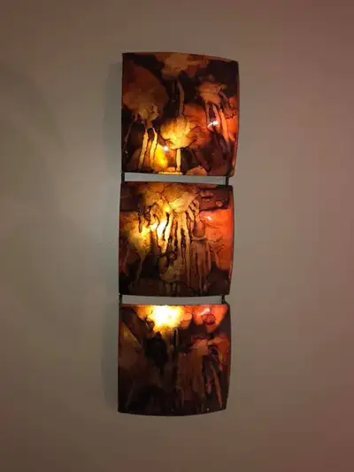 Illuminate your living space with this unique, used wall sconce, featuring a striking three-panel de...