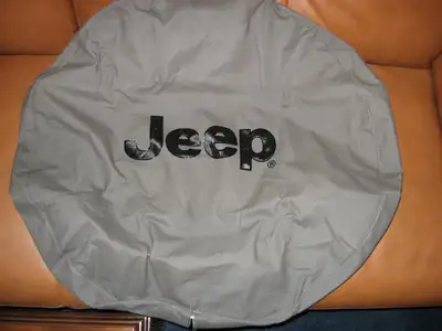 New. Never used. Spare tire cover with black Jeep brand logo on durable khaki denim with Elastic. Fi...