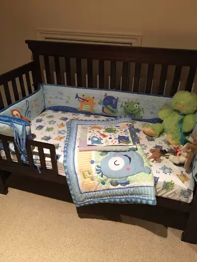 This adorable monster-themed toddler bedding set includes a quilt, fitted sheet, pillowcase, and bum...
