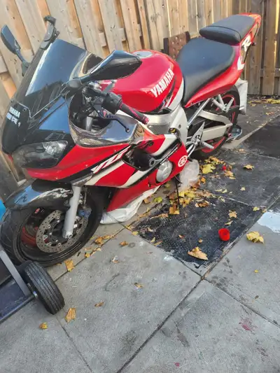 This Yamaha R6 is a super sport bike with a 599cc engine, manual transmission, and a sleek red and w...