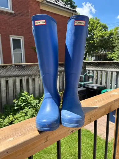 These vibrant blue Hunter tall boots in a US size 10 are the perfect companion for splashing through...