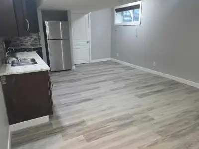 This modern and clean basement suite features a bright, open-concept living area with durable wood-l...