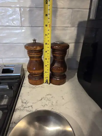 Add a touch of rustic charm to your dining table with this set of wooden salt and pepper shakers, ea...