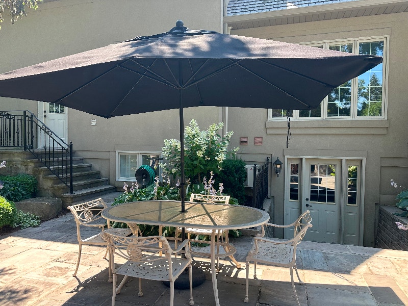 Cast iron patio table, 6 chairs with large umbrella & stand. Patio