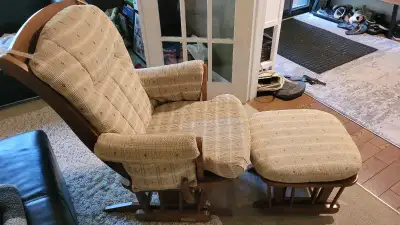 This is a used glider rocker with an ottoman, perfect for a nursery or living room. It features a st...