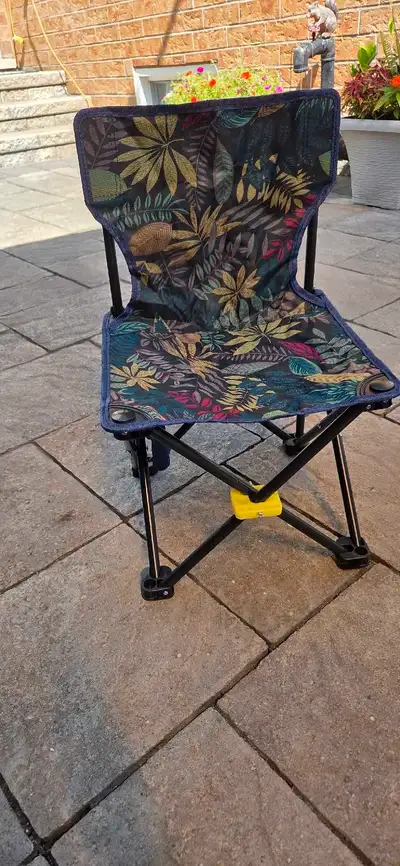 Selling a NEW foldable camping chair for children in ! It has a fun floral pattern and comes with it...