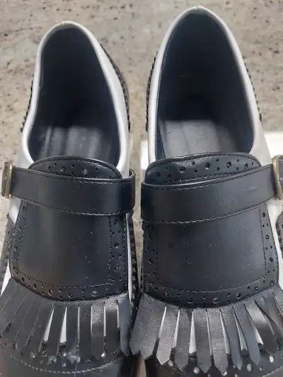 Add a touch of retro flair to your wardrobe with these unique black and white Spectator Monk Strap s...
