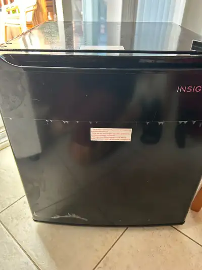 This Insignia compact refrigerator, model NS-CF17BK9-C, offers reliable cooling performance in a spa...