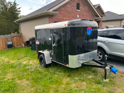 Enclosed cargo trailer 5' x 8' single axe with side door and rear ramp. Floor has been coated with n...