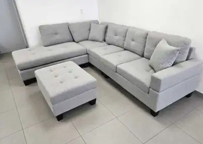 This is a stylish, nearly new, six-seater light grey sofa set that includes a matching ottoman, perf...