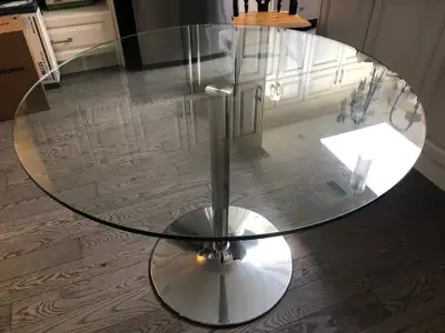 Selling a round dining table with a glass top and a chrome pedestal base. Glass surface is 1 meter a...