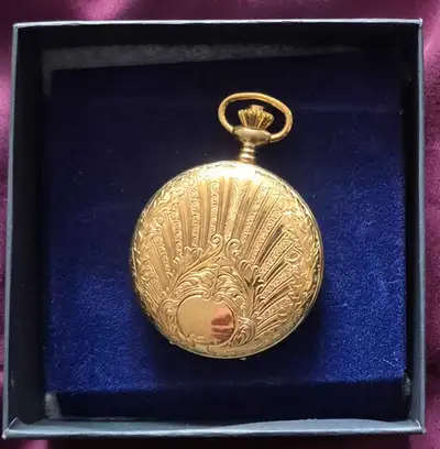 This elegant vintage-style pocket watch features intricate decorative engraving on the front case, s...
