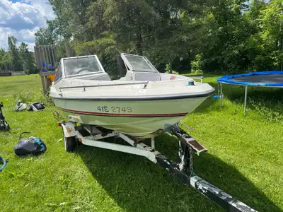 Classic Sunray bowrider boat has a white fiberglass hull with red and black accents. It is equipped...