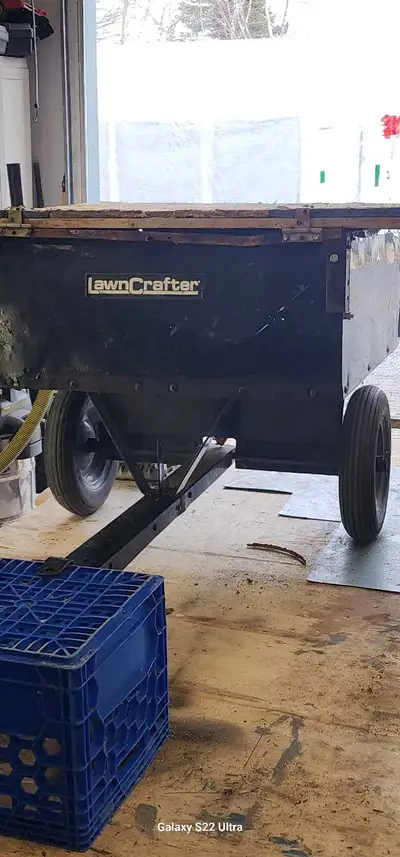 Petite remorque pour jardin avec panneau sur le dessus et arrière amovibles. Elle est aussi dompeur...