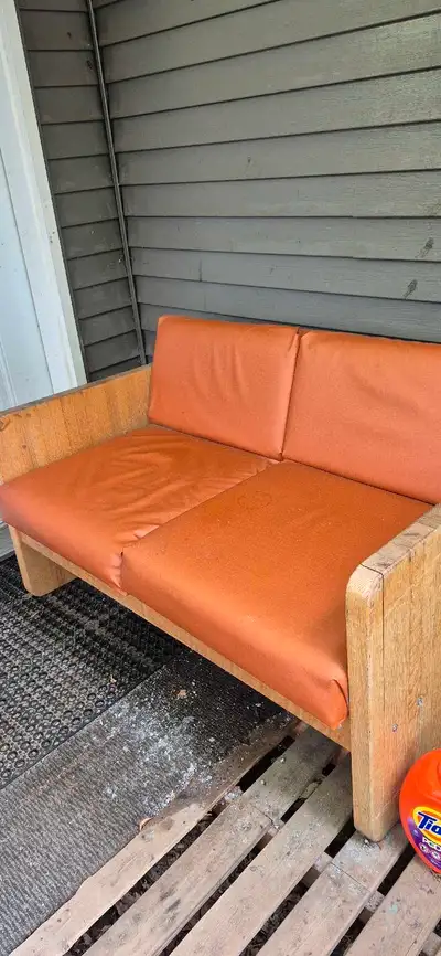 This wooden couch, featuring a sturdy frame and comfortable cushions, is perfect for adding a rustic...