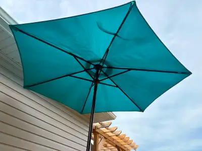 Year old blue umbrella with weighted stand. OBO