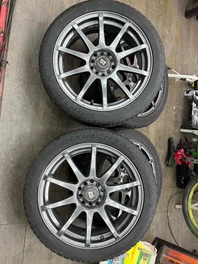 These pre-owned Continental ExtremeContact summer tires, sized 215/45 R17, are mounted on stylish mu...
