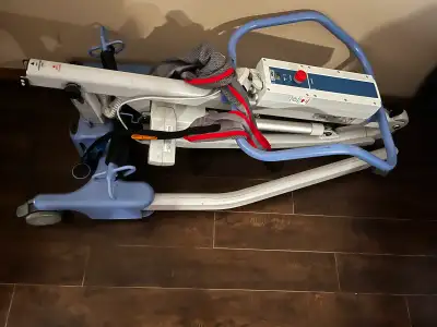 Really well maintained A patient lift. It is folded. The frame is white and blue. There is a power u...