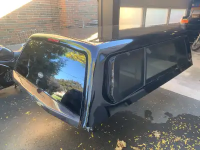 Top of the line tuck cap. Frameless door, tilt out windows so the bed stays dry when driving in the...