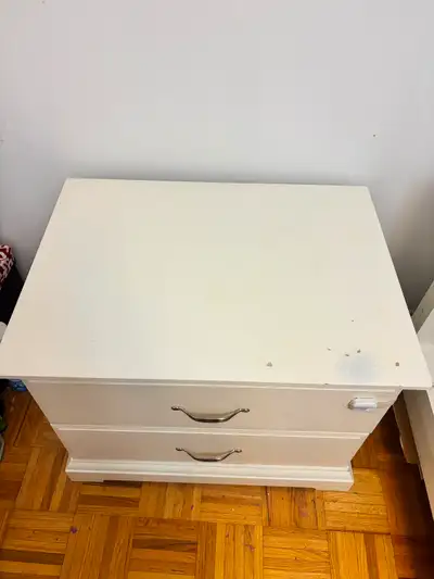 White IKEA side table/nightstand with two drawers. Dimensions are 28” (length) x 21” (width) x 22” (...