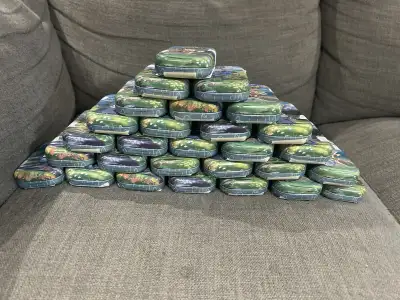 Available is a huge lot of Pokemon tins and cards. 30 available. Within each tin are at least 50 ass...