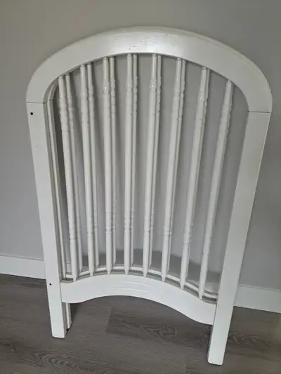 White wooden baby crib. Has marks and some splitting on wooden legs as pictured where it must have g...