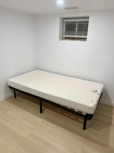 The private room features a twin bed with a frame and mattress, ideal for a student or single profes...