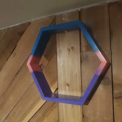 Pine hexagon shelf finished with teal, coral, and purple spray paint. H: 15" x W: 17" x D: 3" Made b...