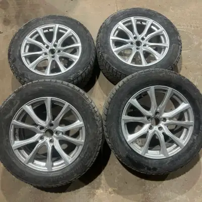 Set of four 245/60/18 Bridgestone Blizzak snow tires mounted on aftermarket aluminum alloy rims. Tir...