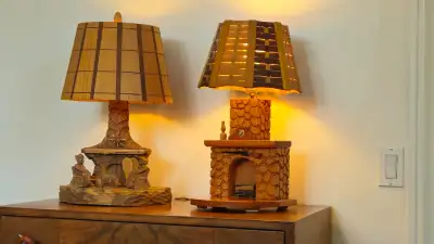 2 lampes en bois sculptee. 1 avec 2 personnages et 1 chien 13 x 20 po. $25.00 1 avec horloge et foye...