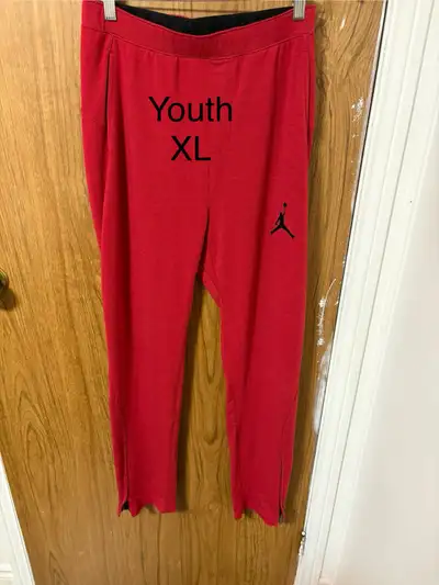These are a pair of gently used Jordan youth XL pants in red with a black logo, suitable for 13-15 y...