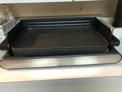 This reversible electric grill/ griddle has a removable splatter screen around it to prevent spatter...