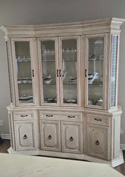 Mid-1980s dining room suite with: A light hardwood pickled oak china cabinet (china hutch) with glas...