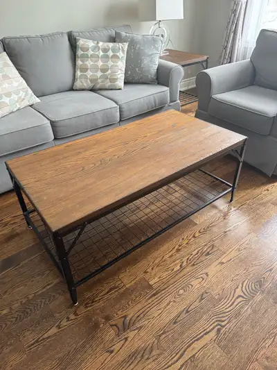 Here's a lovely coffee table with a wood top and a black metal frame! It has a nice, rustic look and...