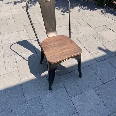 Modern side chair with a brown-gold metal frame and wooden saddle seat. Strong, stylish, and comfort...