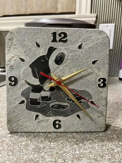 This unique carved soap stone clock features an Inuit carving scene, perfect for adding a touch of C...