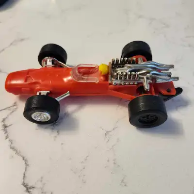 Relive the thrill of the race with this vintage 1960 Formula F1 toy car, featuring a vibrant red bod...