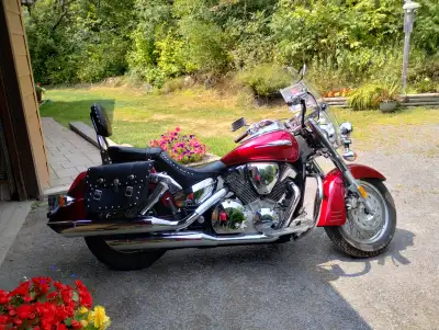 This is cruiser style done right – deep cherry red paint, gleaming chrome, and studded leather saddl...