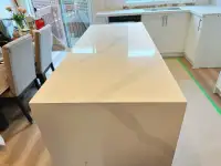 A minimalist kitchen countertop, backsplash, and island