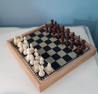 Folding wood chess set with a metal overlay on top and plastic pieces with a magnetic bottom - set i...