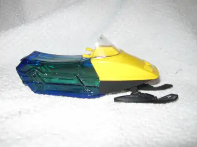 FOR SALE Avon snowmobile windshield has small crack on it. Bottle is full of tai winds aftershave.