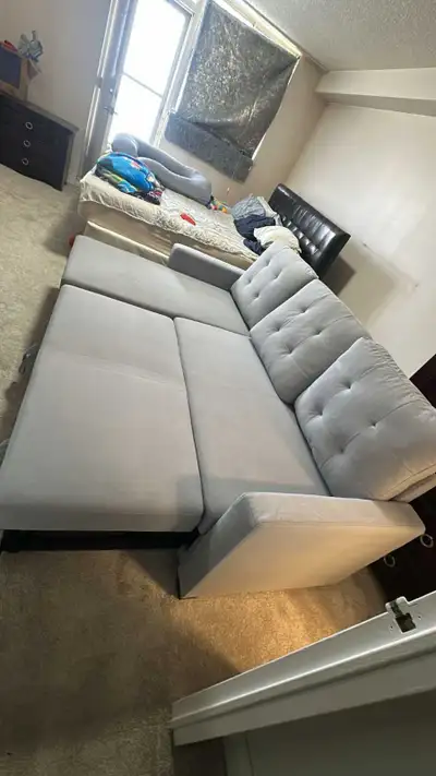 This is a stylish, used grey sectional sofa, perfect for a living room or entertainment area. The se...