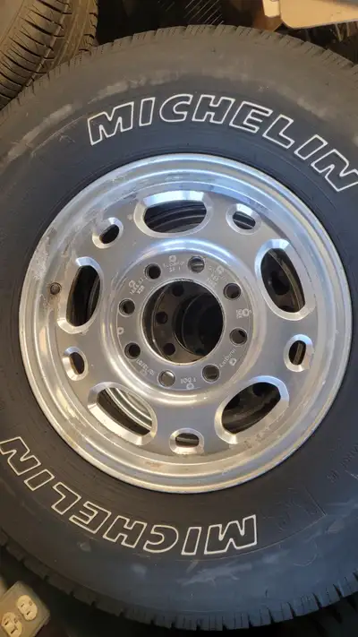 Four tires on four 8-bolt, 16-inch rims in good condition. The rims are for a Chevy Silverado.