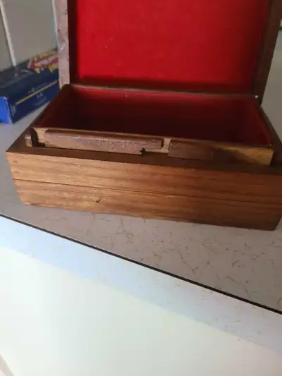 This charming wooden jewelry box features intricate carved lattice detailing on the lid with inlaid...