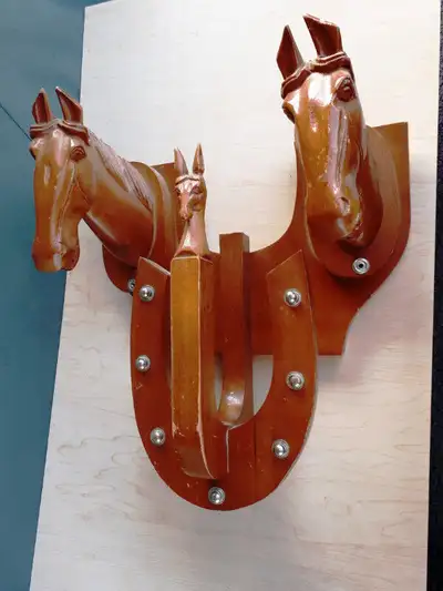 Wall hanging horse shoe rack. About 16 inch by 12 inch. Hand carved solid Wood. 3 horse heads, or ma...