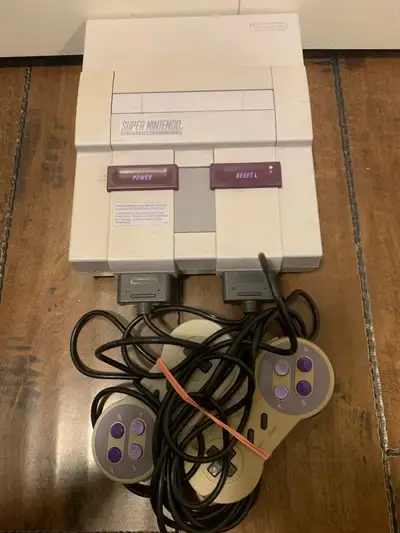 SNES Console with two controllers no cords! Relive the glory days of gaming with this used Super Nin...
