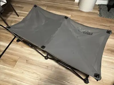 Durable folding dog cot has a grey mesh fabric surface and a black metal frame. This Cabela's brande...