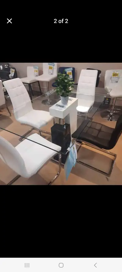 Glass top dining table with 6 chairs (4 black and 2 white) $760., View more