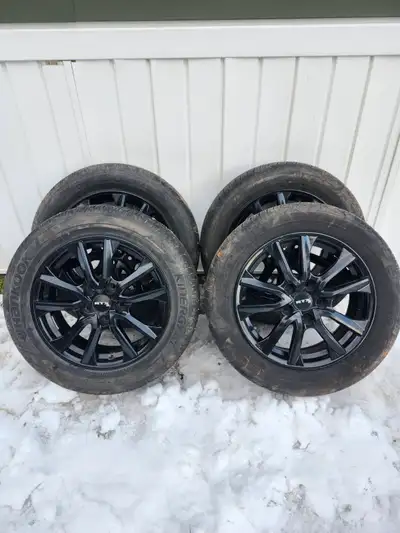 Set of four black 16 " RTX rims mounted with Hanook Kinergy GT 215/55R 16" tires.